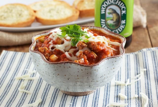 Pizza dip inside a bowl with cheese on top.