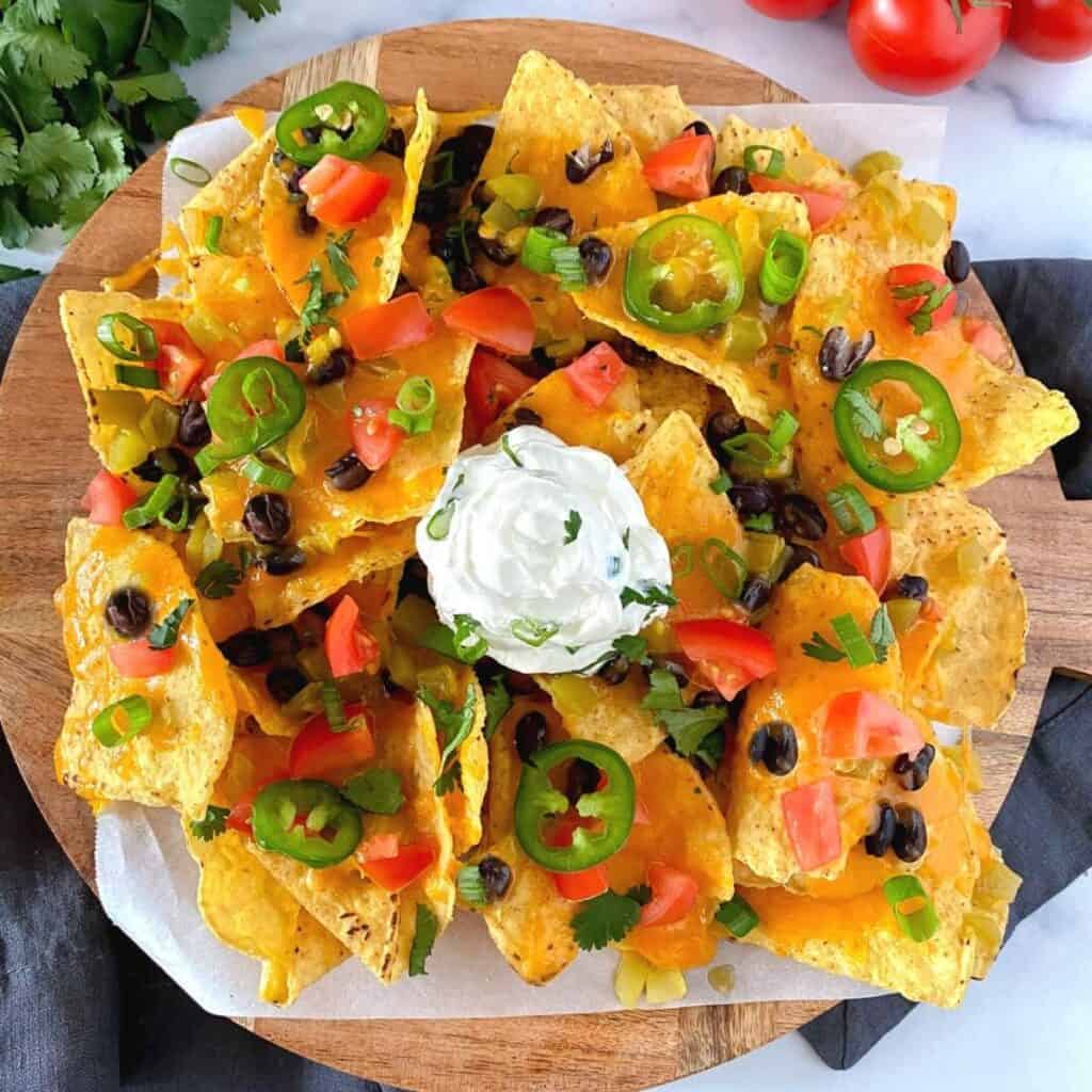 air fryer loaded nachos with cheese on a plate.