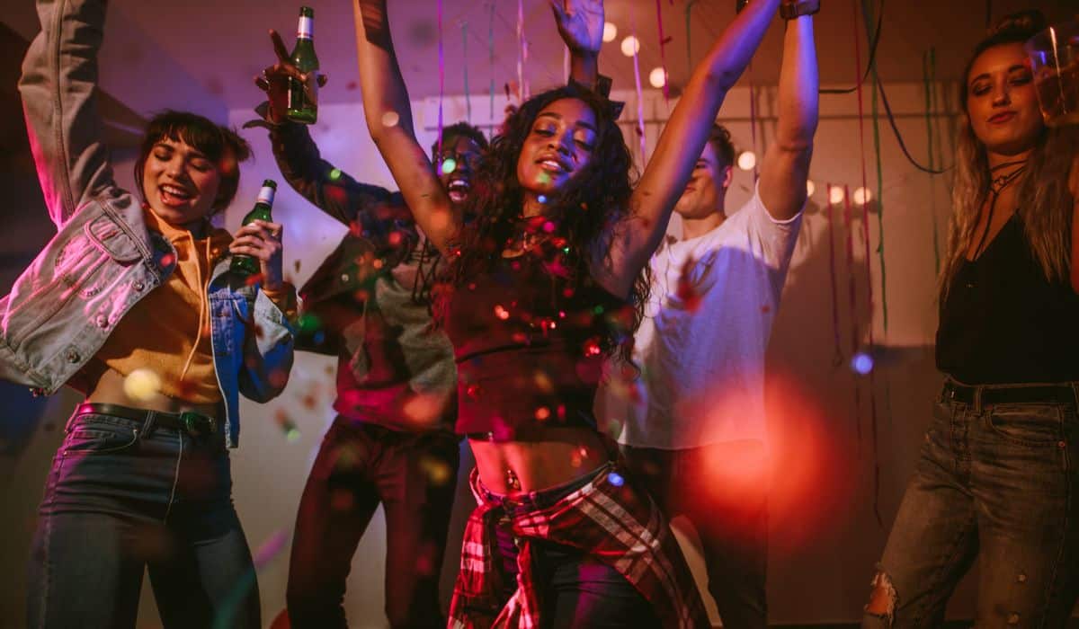 Adults at a house party dancing.