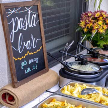 Pasta bar with pasta and sauces on table.