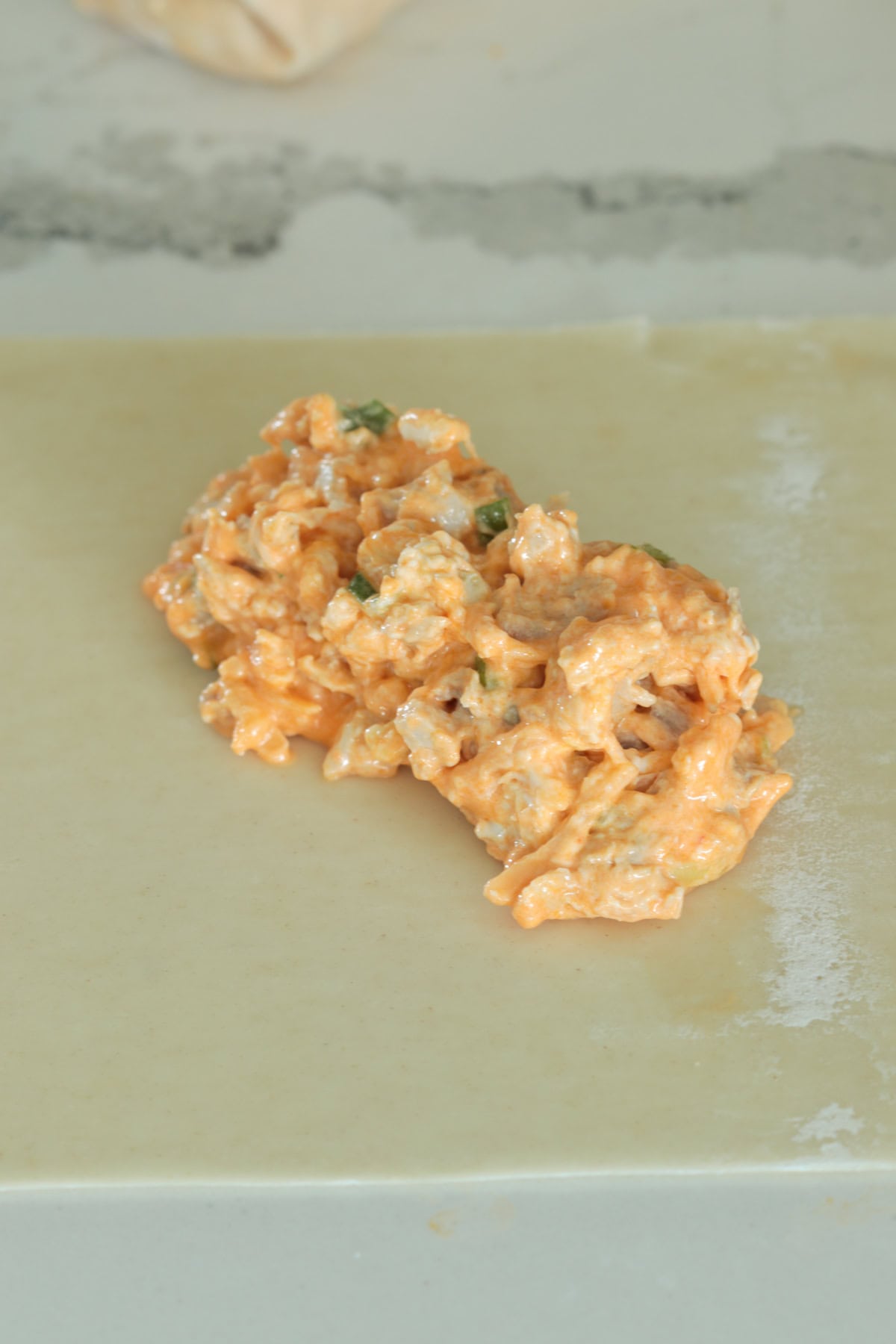 Buffalo chicken filling on egg roll wrapper.